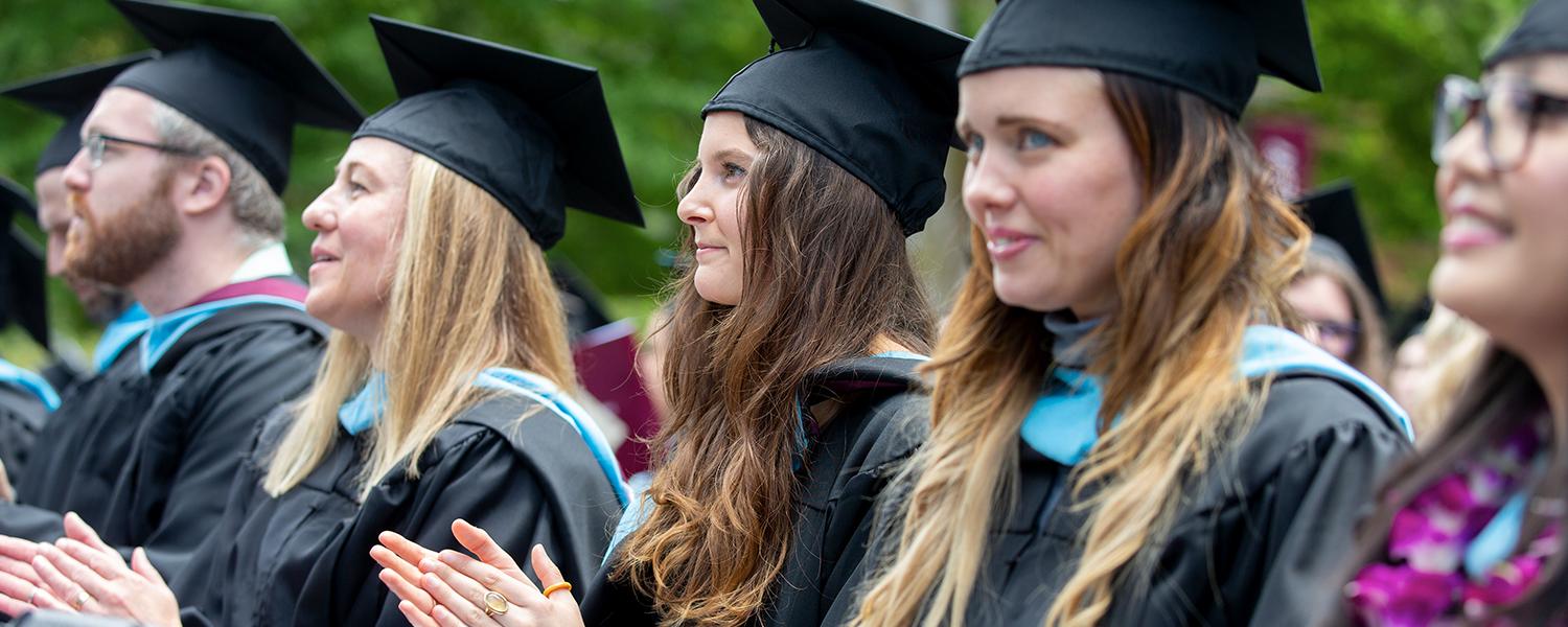 Several graduate students participate in Graduate Commencement, wearing their regalia.